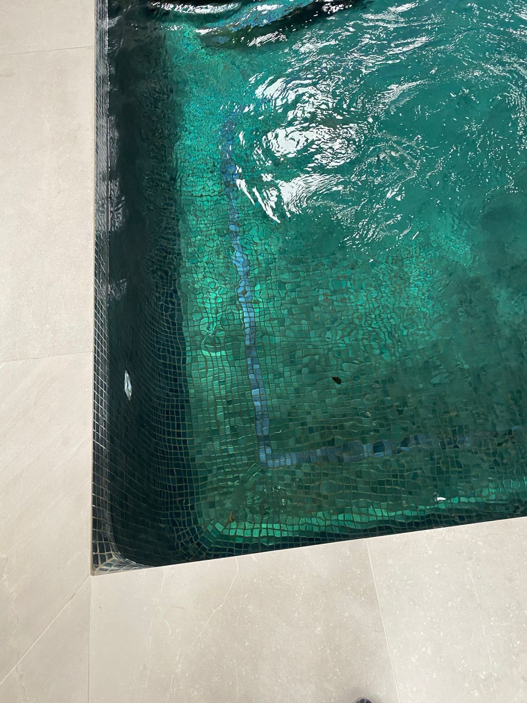 Mosaic tile accents in green were incorporated along the waterline, complemented by contrasting bands and borders.