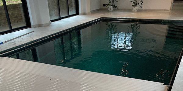 Indoor swimming pool with Automatic Swimming Pool Cover - by UK Swimming Pools Ltd