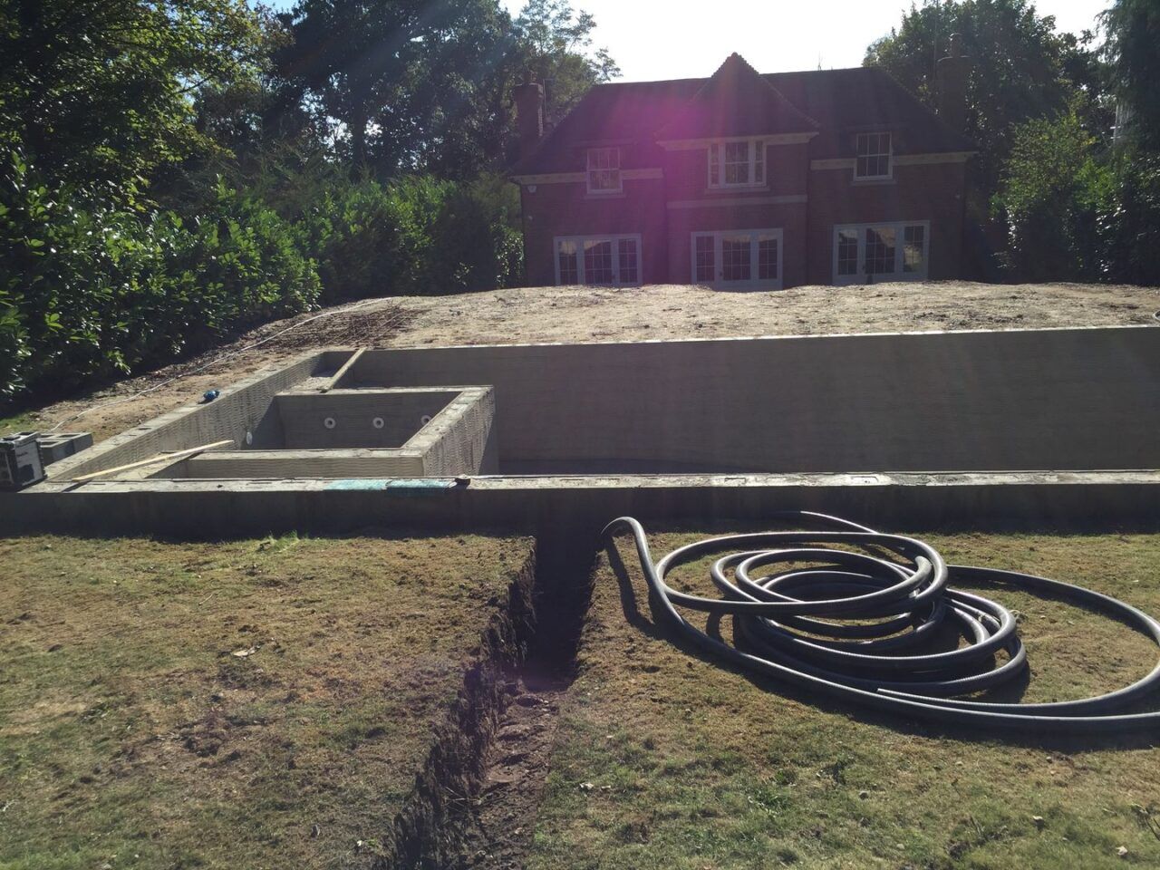 The water pipes being added to the side of the pool