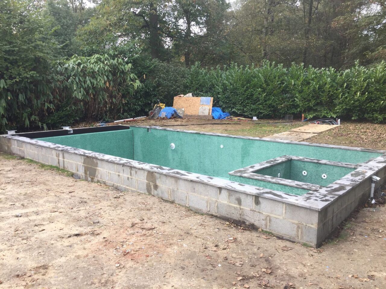 A wider view of the swimming pool after the tiling has been done