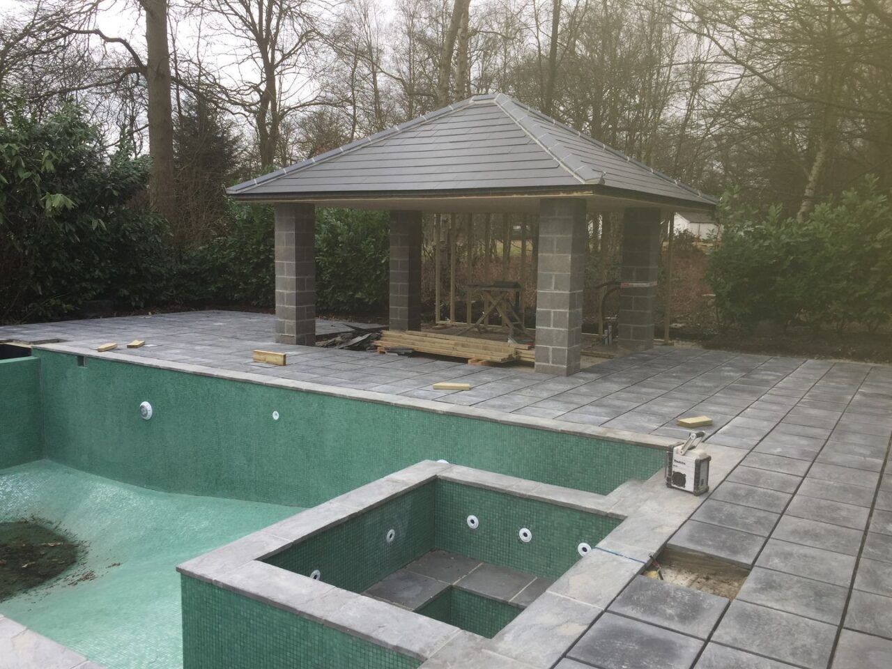 The outdoor kitchen columns and roof is ready and the patio pavement has been installed