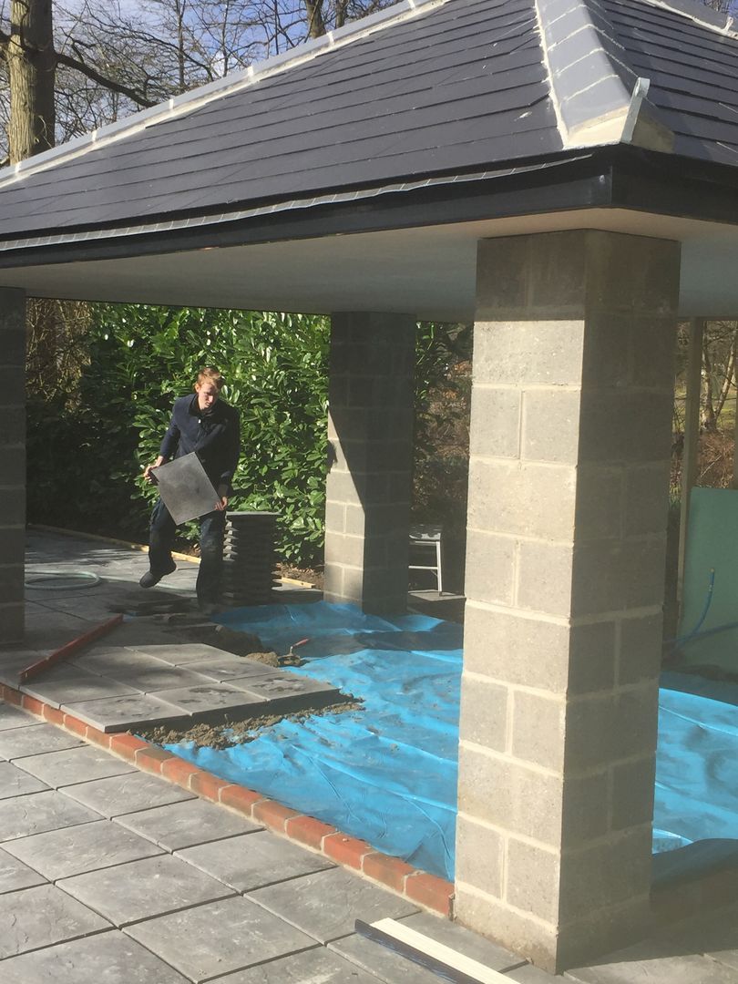 The pavement tiles are getting installed under the outdoor kitchen area