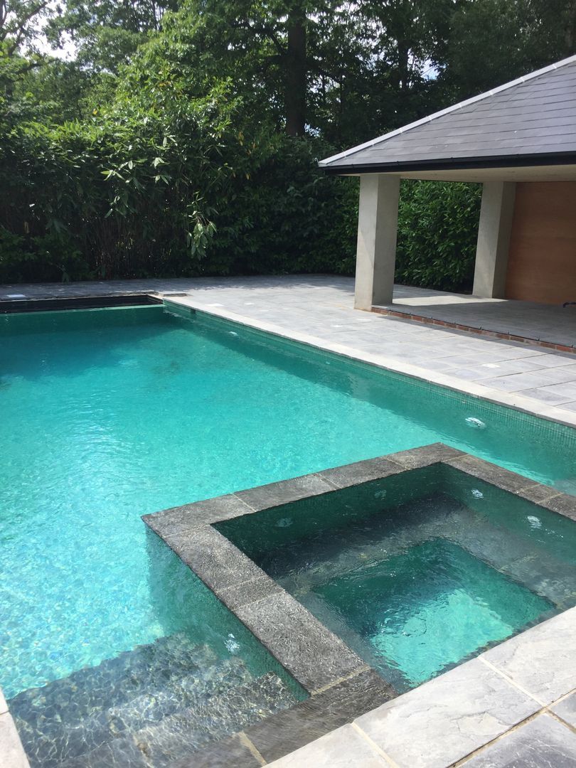 The elegantly designed pool and spa combination with the outdoor kitchen area