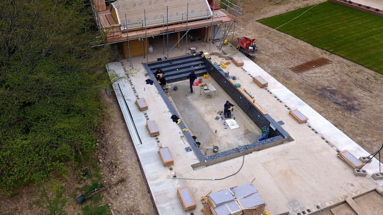 The bottom of the swimming pool is being prepared for the new high-end black and silver mosaic tiles