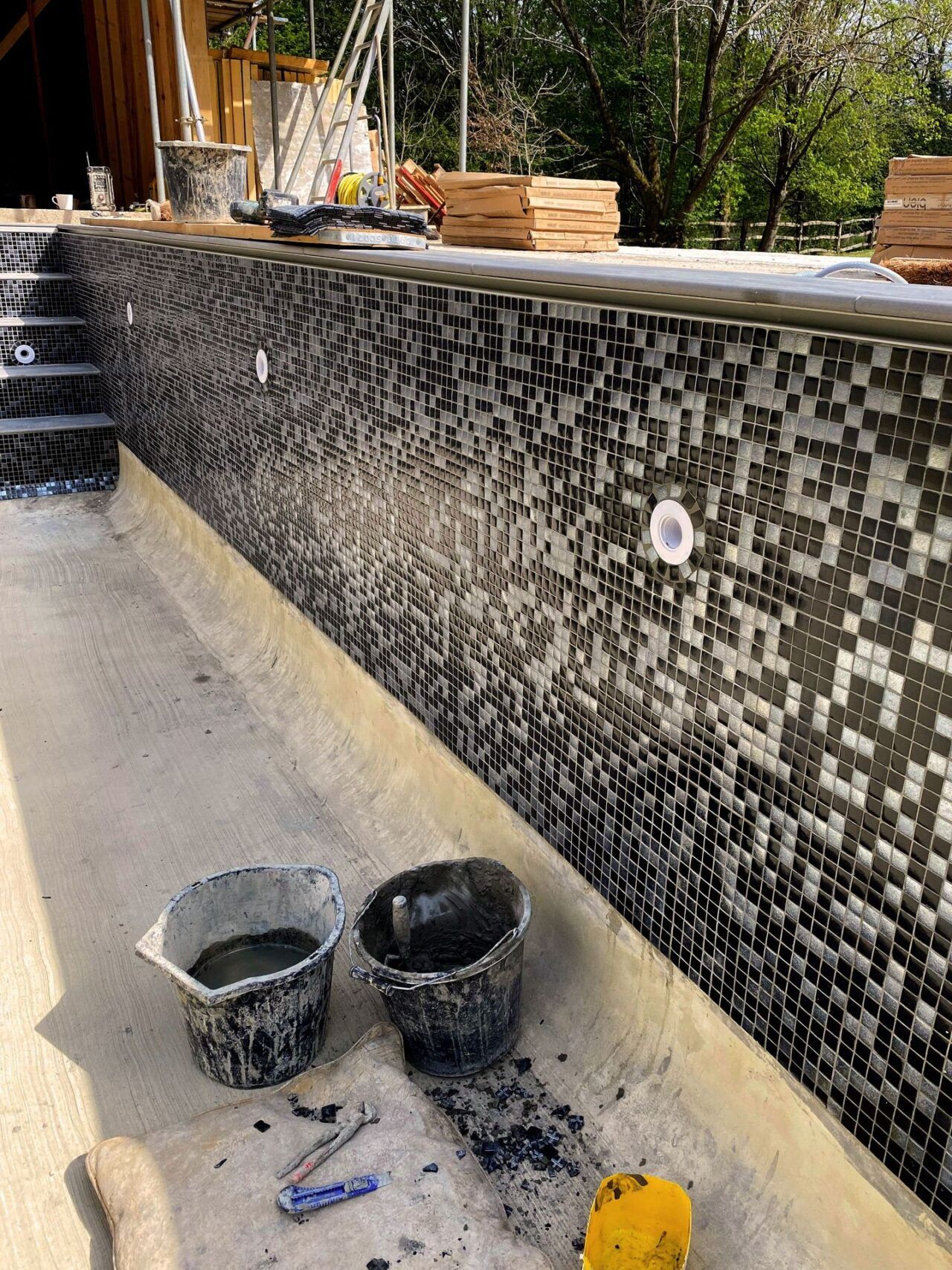 Close-up of the side of the swimming pool while the tiles being installed