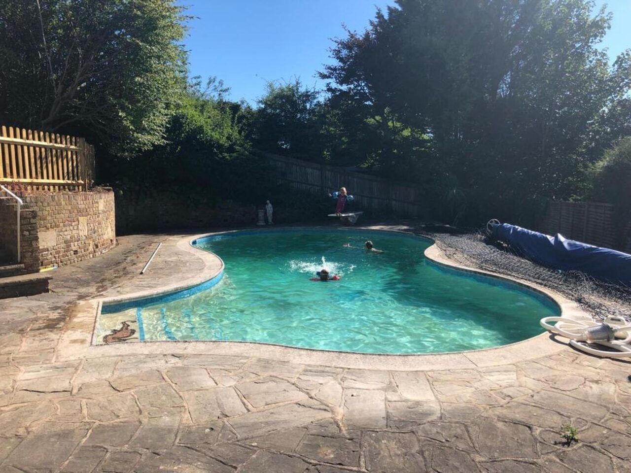 The original irregularly shaped residential swimming pool before the renovation The original irregularly shaped residential swimming pool before the renovation