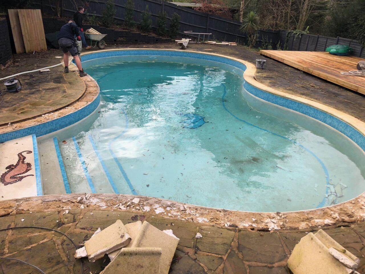 The original irregularly shaped residential swimming pool before the renovation The original irregularly shaped residential swimming pool before the renovation