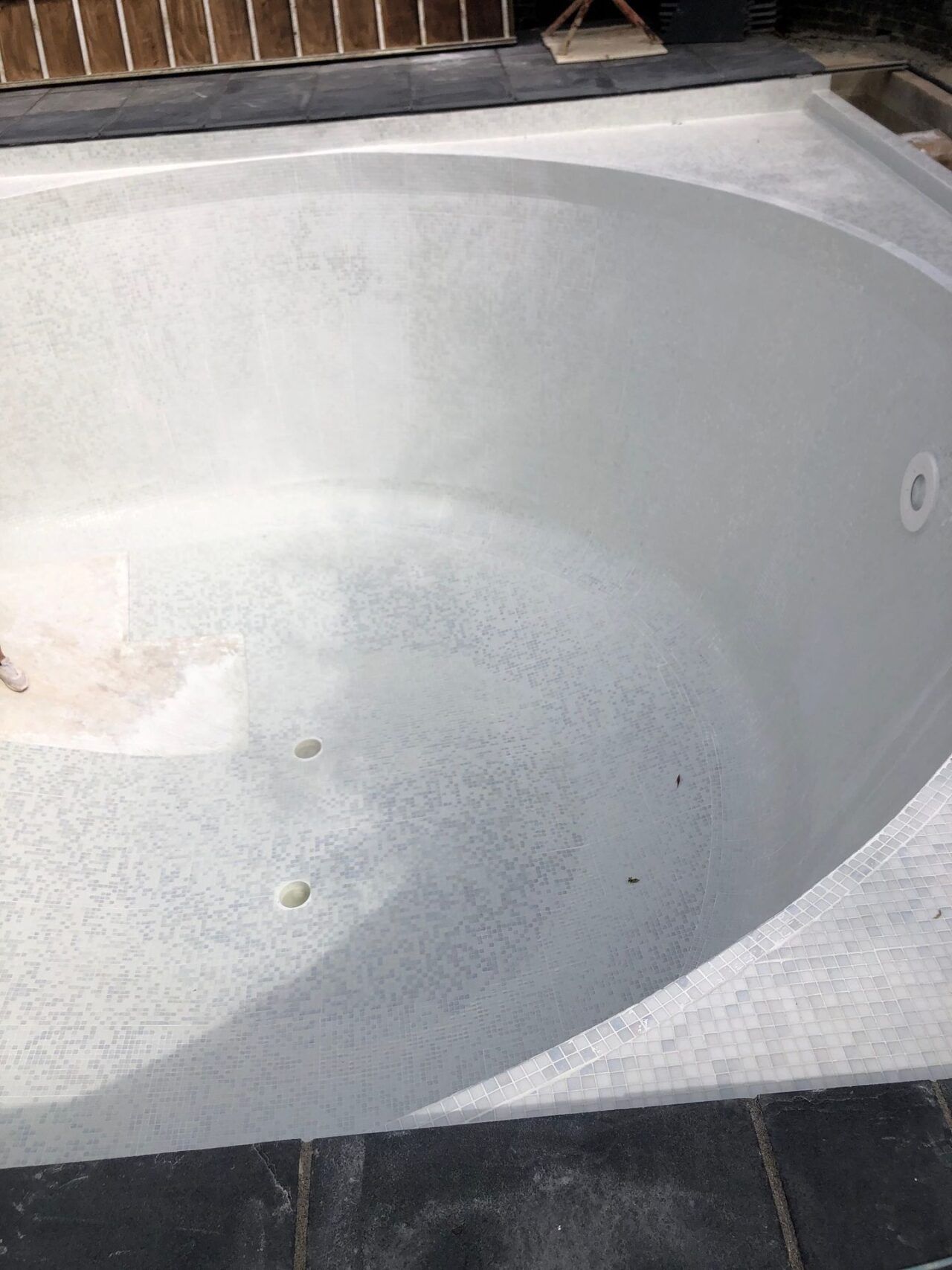 The entire pool interior was retiled with contemporary white glass mosaics and contrasting step demarcations The entire pool interior was retiled with contemporary white glass mosaics and contrasting step demarcations