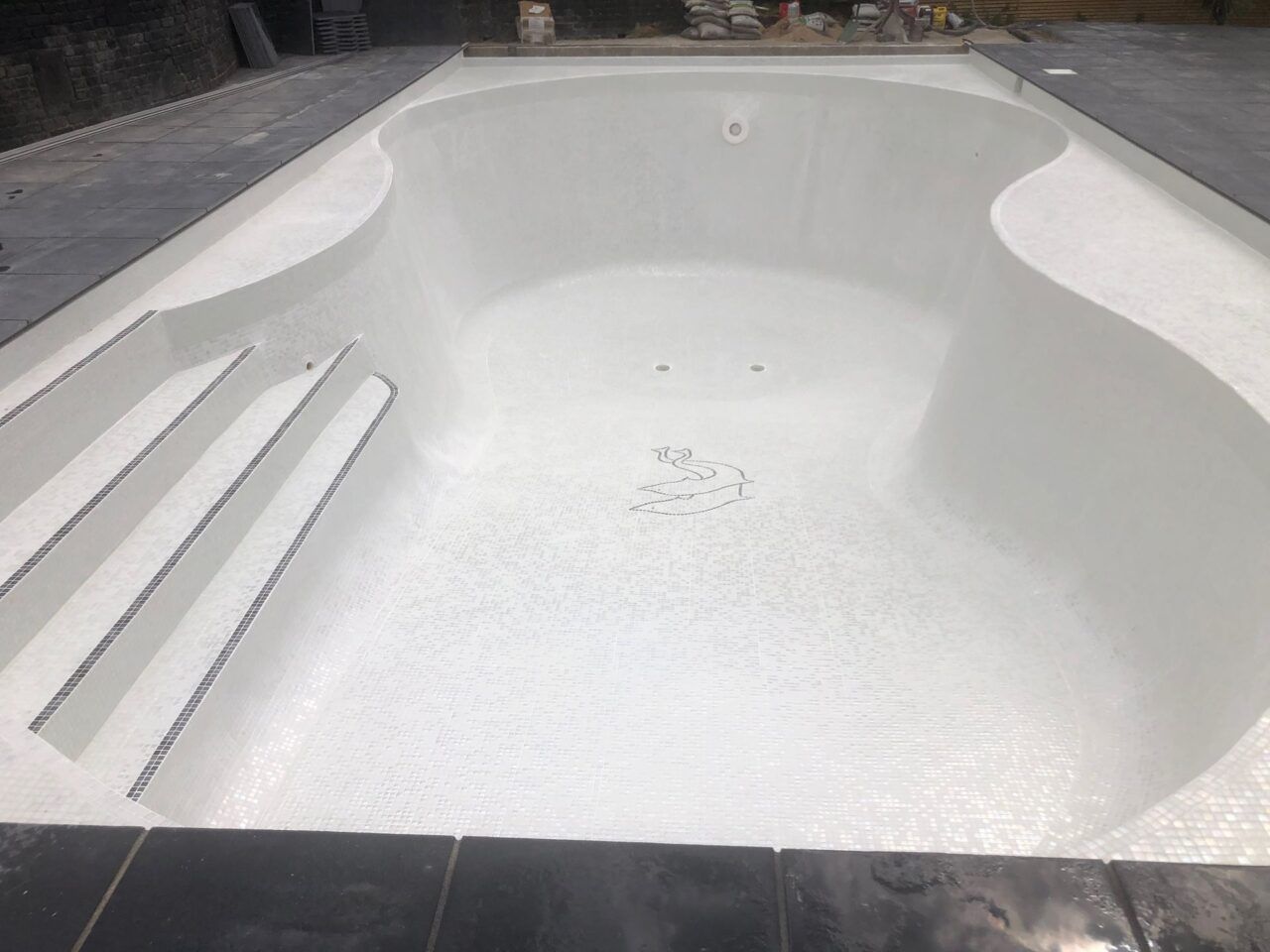 The entire pool interior was retiled with contemporary white glass mosaics and contrasting step demarcations The entire pool interior was retiled with contemporary white glass mosaics and contrasting step demarcations