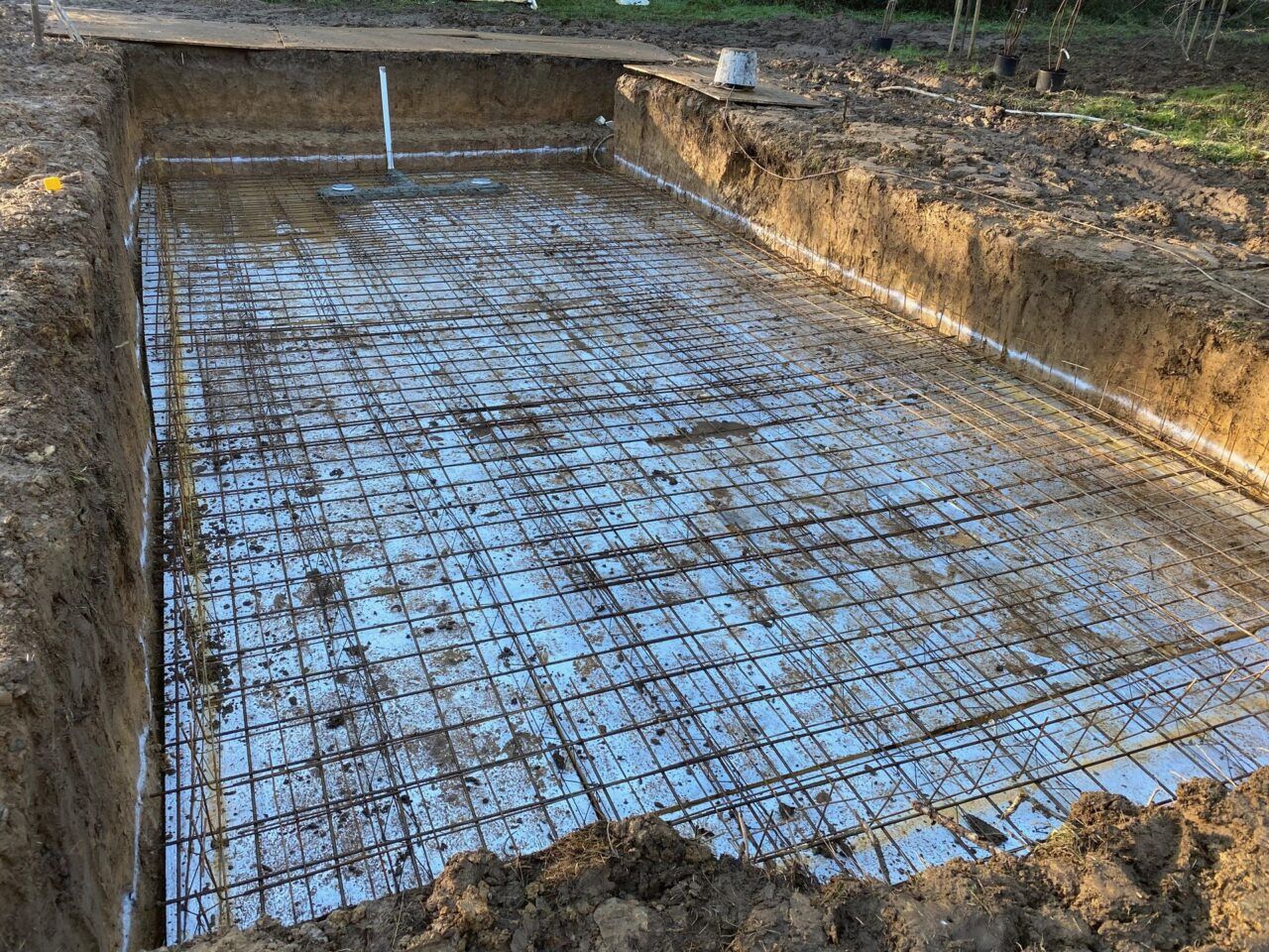 Metal wireframe being installed under the entire swimming pool