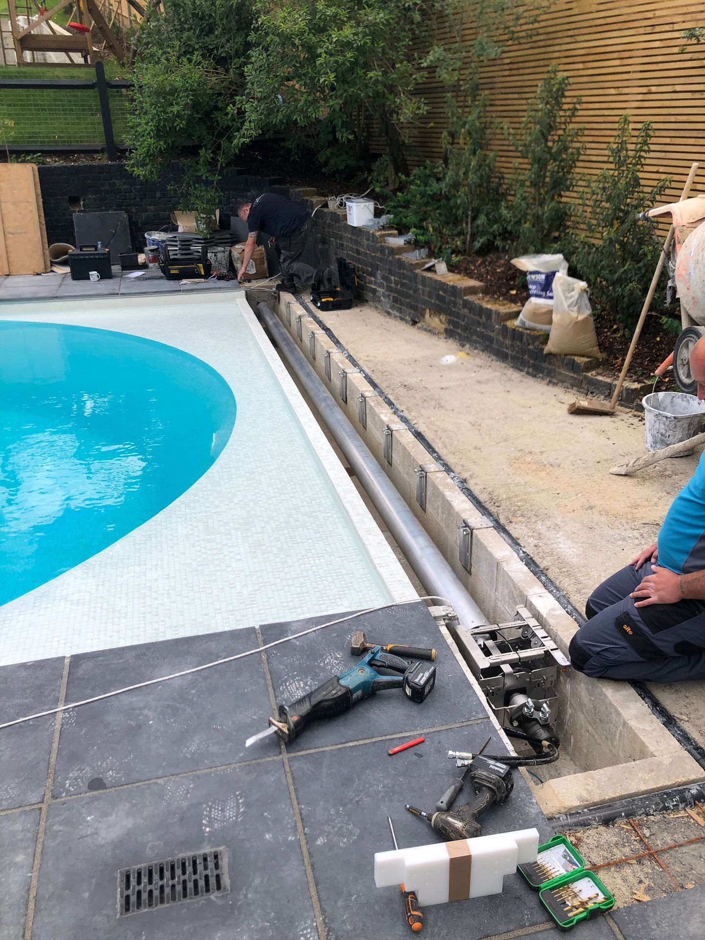 A close-up of the installation of the new pool cover rotary system