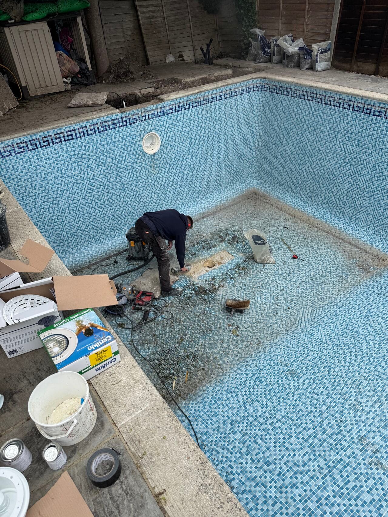 Newly installed semi-automatic retro-fit swimming pool cover on a refurbished kidney shaped swimming pool